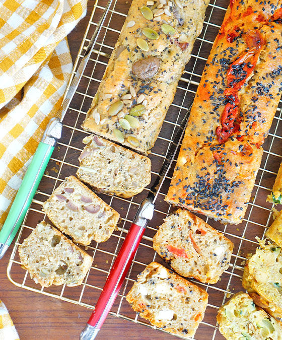 Part de cakes salés pour l'apéritif, courgette-curry, tomates séchées-sésame-feta, olives-graines bio
